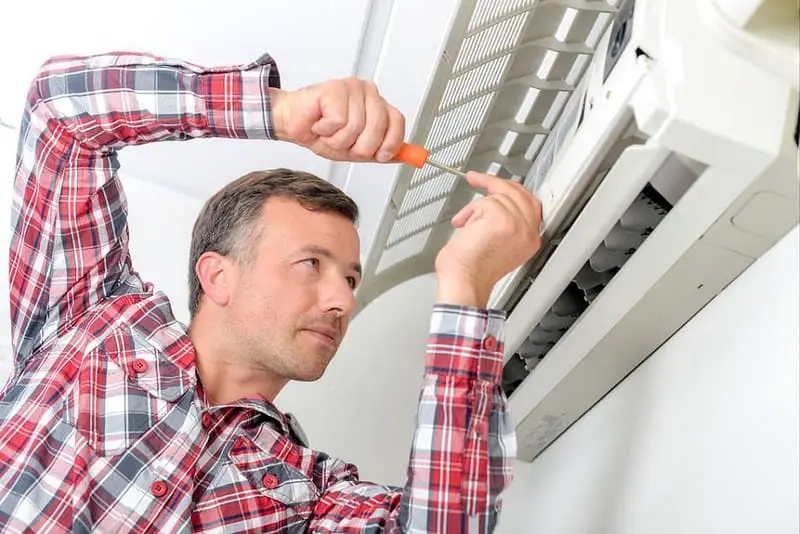 man replacing air conditioner filters