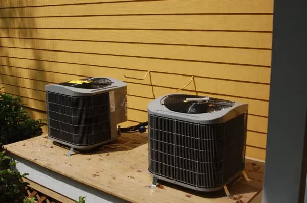 The American Standard Air Conditioner on the top of wood table and a leaves beside