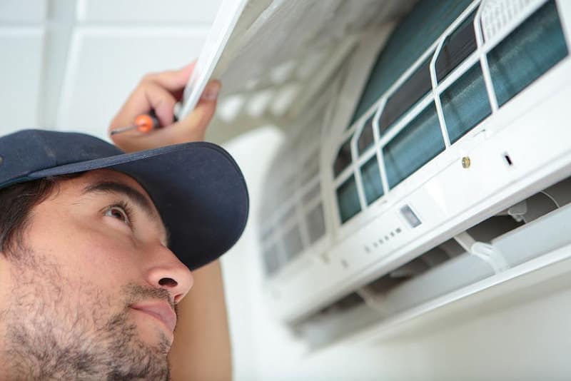 man checking the air conditioner filters